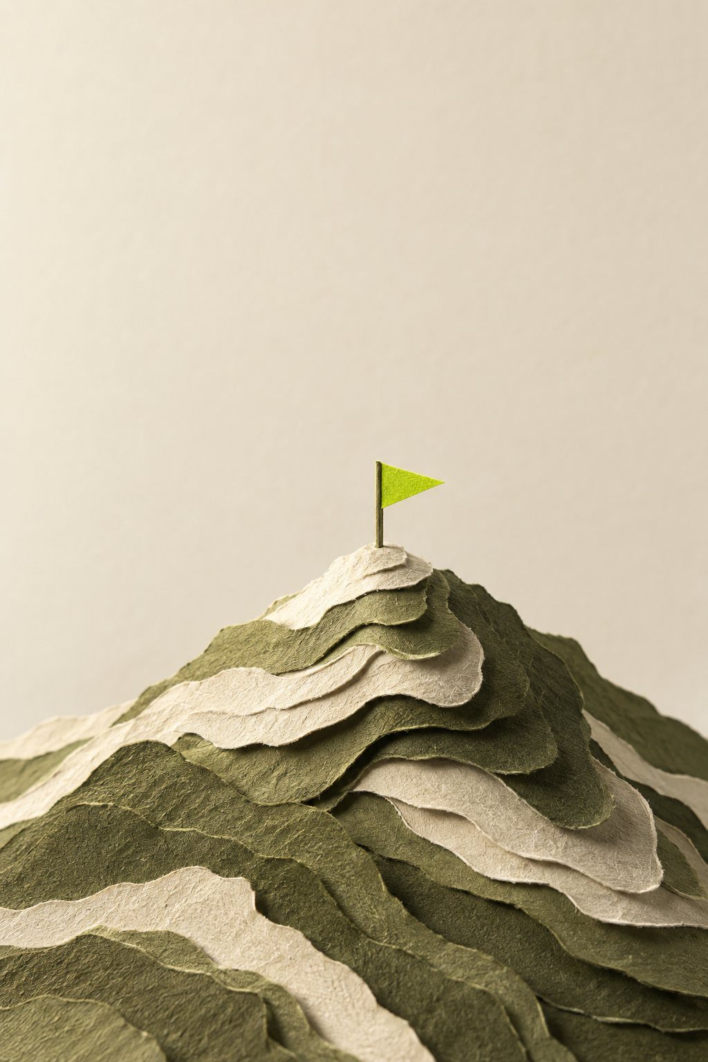 A layered paper summit with a lime flag
